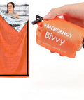 Emergency Thermal Sleeping Bag Kit With Drawstring Storage Pouch And Survival Whistle; orange Mylar blanket in use