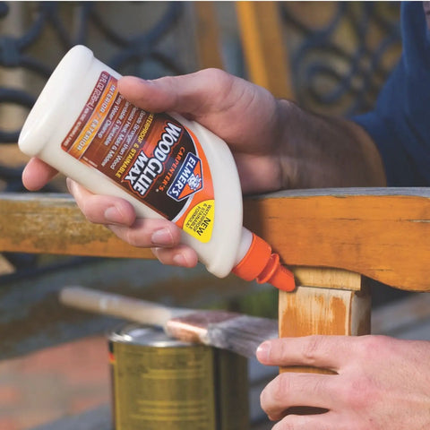 Person applying Elmer's Carpenter's Wood Glue Max 1 Gallon Tan Extra Strength on wooden furniture outdoors