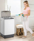 Woman carrying basket of colorful clothes to Slick 17.6 Lbs Compact Portable Washer With Clear Led Screen And Ten Program Settings For Swift Laundry Loads In Tight Dorms Or Apartments With Heavy Duty Drain Pump And Smooth Stainless Drum.