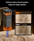 Artilume T1 foldable laser engraver—front view, dark gray body with orange accents and blue laser engraving a tiger on wood.