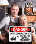 Couple holding Heads Up Construction Site Sign Aluminum 8x12 Inch Watch For Moving Equipment Warning Sign indoors
