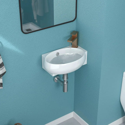 Wall-mounted oval sink with faucet in a modern bathroom with blue walls.