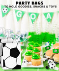 12 Pack Soccer Themed Party Favor Bags With Handles, paper gift bags, displayed with soccer-themed party table setup.