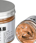 Copper Based Anti Seize Grease 100g Waterproof Long Lasting Paste For Brake Bolts Exhaust Nuts And Threaded Parts Easy Application Pro Grade Lubricant For Mechanics And Technicians shown in a jar with lid off, displaying copper paste inside.
