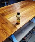 Wood Polish And Conditioner With Carnauba Wax And Beeswax And Orange Oil For Antique Furniture Dining Tables Cabinets And Trim Delivers Soft Luster And Warm Natural Glow And Rich Grain Pop 8 Oz on a wooden table
