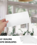 Hand holding White Self Seal Confidentiality Envelopes 115mm By 225mm For Office Documents And Shipping in office setting.