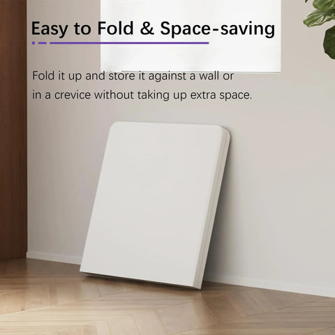 Heavy Duty 4 Foot Folding Table With Carry Handle And Mesh Bag, White, folded against a wall for compact storage, space-saving design