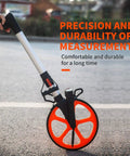QERTYHKK Measuring Wheel Distance Measurement Tools Mechanical with orange wheel on pavement for precise measurements.
