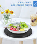 12 Inch Rotating Turntable With Steel Ball Bearings For Flat Panel Monitors TVs Potted Plants And Stereo Speakers A Versatile Heavy Duty Black Swivel Stand For Home Office Desk Or Display Setup holding a salad bowl and drink on a table