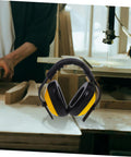 Lock Down Every Distraction Heavy Duty Noise Reduction Earmuffs on a workbench, designed for woodworking, featuring a black and yellow color scheme.