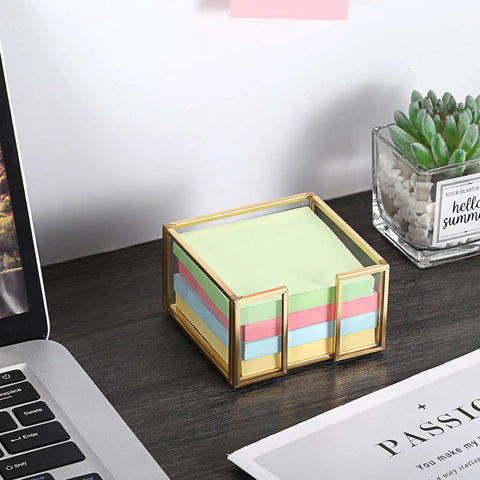 Gold Trimmed Glass Sticky Note Holder With Non Slip Pads For 3x3 Inch Notes on a desk with a laptop and plant