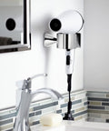 Voss Hair Dryer Holder Wall Mount In Bronze Finish Coordinates With Voss Faucets And Bath Accessories Includes Mounting Hardware For Easy Installation No Fuss Setup Crisp Edges And Fashionable Modern Bathroom Accessory with hair dryer mounted near sink.