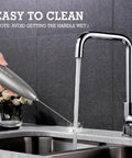 Handheld Milk Frother With Stand, Electric Foam Maker With Stainless Steel Whisk being rinsed under a faucet, gray finish, easy clean