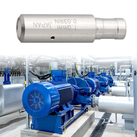 Close-up of cylindrical EDM wire guide nozzle with side hole; metal body against blue industrial machinery backdrop.