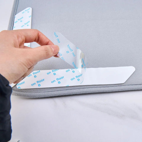 Hand applying 8 Pack Washable Non Slip Rug Pads Double Sided For Floors Black Reusable Rug Grips on tile surface with adhesive backing