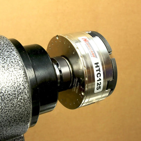 HTC125 5 Inch Four Jaw Woodturning Chuck Kit on lathe, chrome-plated steel body, visible dovetail jaws, scroll chuck