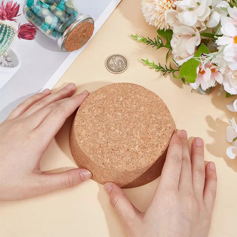 Hands holding Large Cork Stoppers 4.1 to 4.7 Inch Bottle Corks, Tapered Wooden Plugs For Canning Jars on table with flowers
