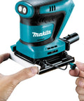 Hands attaching paper to 18V Cordless 1/4 Sheet Finishing Sander With Two Speed Control 11K And 14K OPM Uses Four And A Half Inch By Four Inch Abrasive Paper Large Clamping Lever Tool Only