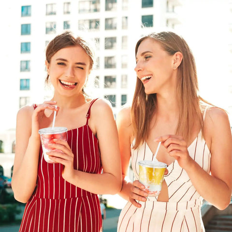 Women enjoying drinks in Clear 12 Oz Cups With Lids And Straws 50 Pack For Iced Coffee Smoothies Milkshakes Juices To Go Durable BPA Free PET Plastic Party Ready For Home Office BBQs And Travel