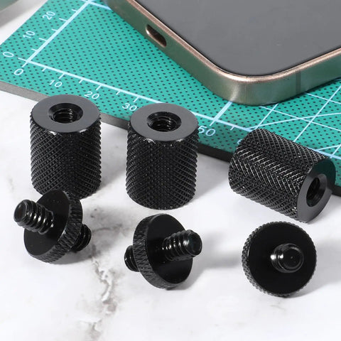 Six Pack 1/4 Inch To 1/4 Inch Threaded Tripod Screw Adapter, aluminum mounts on green cutting mat with smartphone.