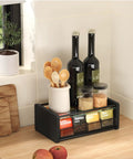 Kitchen organizer with spices, bottles, and utensils on countertop next to window and cutting board