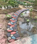 Garden path created with Two Packs Concrete Slab Molds For Walkways And Paths Irregular Grid Pavement Mold, stone style, black 34 cm.