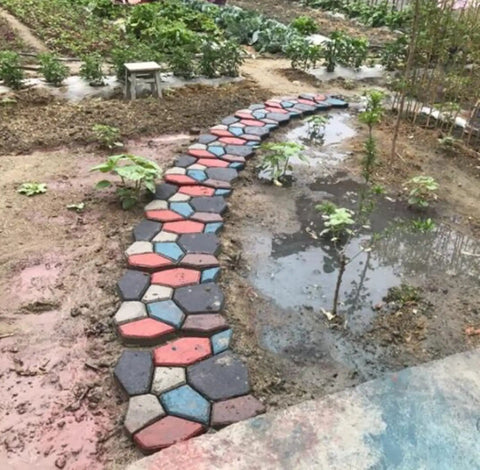 Garden path created with Two Packs Concrete Slab Molds For Walkways And Paths Irregular Grid Pavement Mold, stone style, black 34 cm.