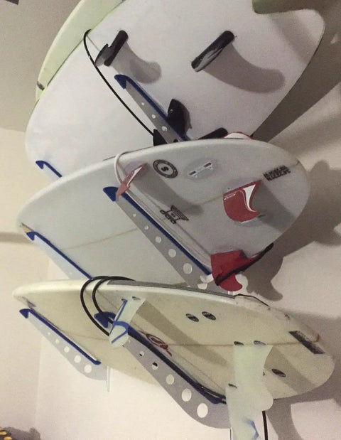 Dude Approved Surfboard Wall Mount Rack With Padded Arms Holds Four Shred Ready Boards Adjustable Height Wall Storage Organizer Keeps Shortboards And Longboards Secure Off The Floor, displaying three surfboards mounted neatly.