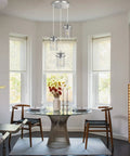 Three Light Glass Pendant Light With Brushed Nickel Finish And Clear Glass Shades Adjustable Cord Cool Farmhouse Ceiling Fixture shown over a dining table.