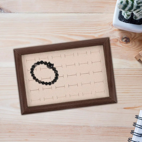 Sleek Wooden Jewelry Organizer Tray With 30 Compartments And A Sick Walnut Finish displaying a bracelet in a compartment.