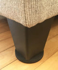 Round 2.5 Inch Reusable Small Furniture Sliders For Hardwood Floors Move Light Items Easily And Protect Floors With Durable Rubber Brown 8 Pack installed under sofa leg on hardwood floor