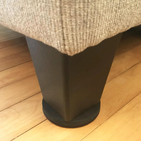 Round 2.5 Inch Reusable Small Furniture Sliders For Hardwood Floors Move Light Items Easily And Protect Floors With Durable Rubber Brown 8 Pack installed under sofa leg on hardwood floor