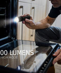 Man using Four Pack LED Tactical Flashlights S300 Pro IPX4 Waterproof Beefy Bright EDC Torches for inspecting oven.