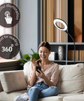Woman sitting on a sofa using a smartphone next to a Gooseneck LED Floor Lamp For Office Reading And Bedrooms Non Glare Eye Safe Lighting 600 Lumens From 3 Watt LED Energy Saver Lit Brightness