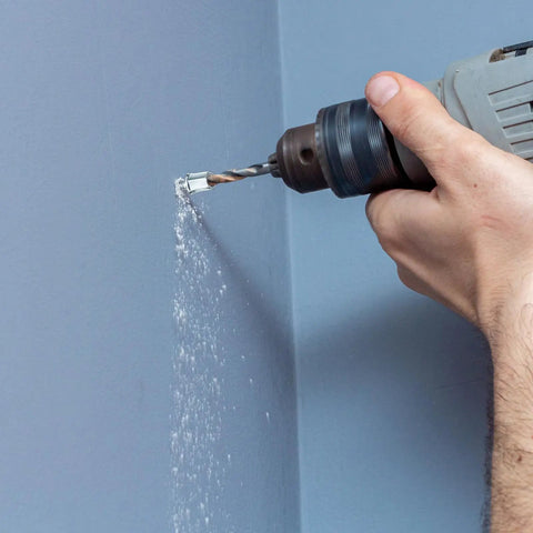 Drilling into concrete wall using 100 Piece Set 3/8 Inch Threaded Rod Anchors for Concrete and Steel, 1/4 Inch Diameter, Zinc Finish.