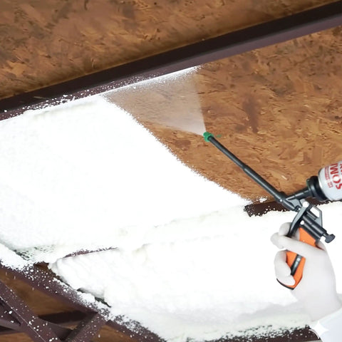 Applying Expandable Polyurethane Spray Foam Insulation for Superior Heat And Sound Control under a ceiling beam.