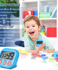 Child holding a blue timer from Set Of 30 Multicolor Digital Kitchen Timers With Magnetic Mount Loud Alarm And Big Digits Countdown To 99 Minutes 59 Seconds Lit, surrounded by toys.