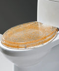 Smooth Ride Silver Foil Glitter Toilet Seat With Soft Close Hinges And Quick Release Mounting For Standard Elongated Bowls on a toilet.