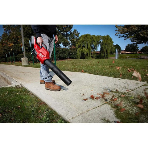 Person using M18 FUEL Cordless Handheld Blower With 120 MPH Air, 450 CFM Power, Brushless 18-Volt Lithium-Ion on a sidewalk