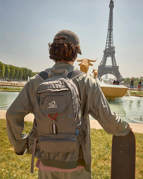 Person wearing Ultra Lightweight 20L Packable Daypack For Travel, Hiking And Camping, Foldable And Compact near Eiffel Tower