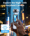 Hand holding Pocket 2.5K Video Recorder With 180 Degree Rotating Lens For Vlogging, cityscape visible on screen at night