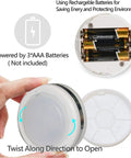 Hand holding Led Puck Lights With Remote Control No Wires Needed Stick On Under Cabinet Lights AAA Battery Powered With Auto Off 30 Minute Timer Six LEDs, showing battery compartment open for AAA batteries.