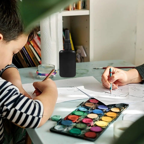 Get These Epic Glue Dispensing Bottles With Precision Nozzle Caps In Sleek Black, perfect for DIY crafts on a workspace.