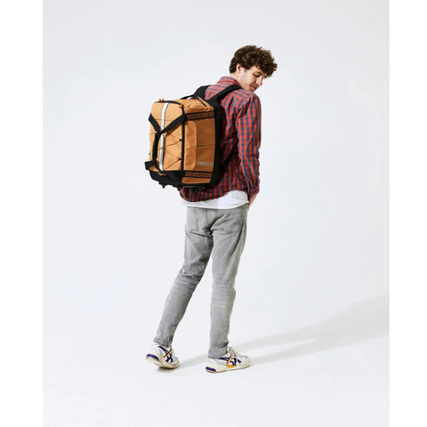 Man wearing Road Ready Three In One Rear Rack Bag That Transforms From Backpack To Duffle To Pannier 37L Capacity