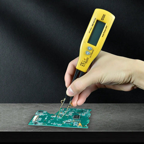 Hand holding yellow digital multimeter with LED clip probes testing a PCB for resistance, capacitance, diodes, and LEDs.