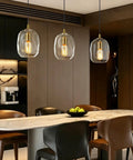 Pendant Lights Kitchen Island, Hand-Blown Clear Glass Brass Gold 9 Inch H, three lights above a dining table with dark wood background.
