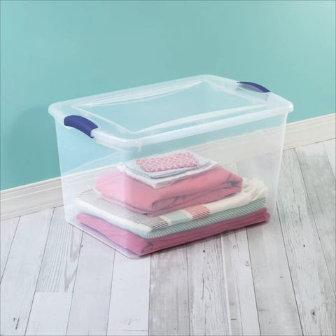 Blue 66 Quart Clear Storage Bin with Latching Lid for Easy Grip Heavy Loads Stackable Plastic Container Organize Clothing Boots and Seasonal Gear with folded blankets inside.
