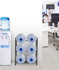 Heavy Duty 3 Tier 5 Gallon Water Jug Rack with six slots in an office, steel water bottle dispenser stand