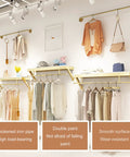 Top Shelf Wall Mounted Clothing Rack System Kit Crafted from Rock Solid Wrought Iron Pipes and Rugged Pine Boards for Boutique or Main Street Closets That Can Take Some Serious Wear and Tear in a showroom with clothing.