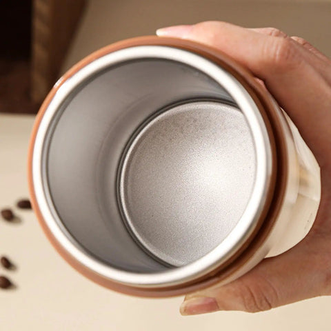 Interior view of Self Heating Coffee Mug With Quick Temperature Display And Totally Spill Proof Lid, showing the silver lining and grip.